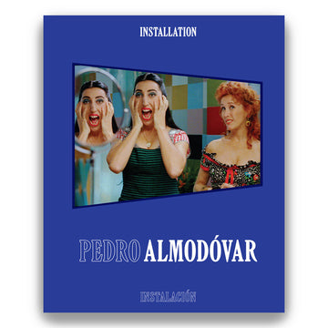 Cover of the book 'PEDRO ALMODÓVAR: INSTALLATION/INSTALACIÓN' featuring a blue background with an image of three women reacting expressively to a situation, set against a colorful backdrop.